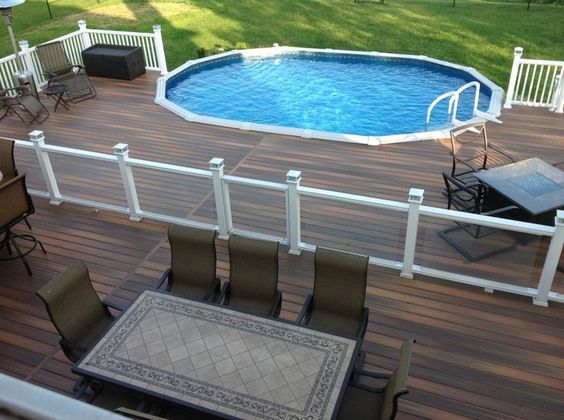 Splendida piscina seminterrata su terrazzo in legno.
