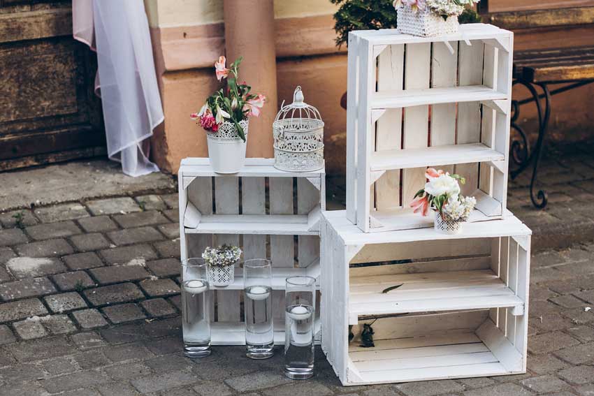 composizione shabby chic fai da te con cassette di legno pitturate di bianco, bello per un matrimonio stile shabby