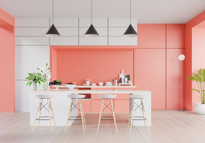 cucina moderna bellissima bianca e rosa, isola cucina bianca con lampade sospese di colore nero.