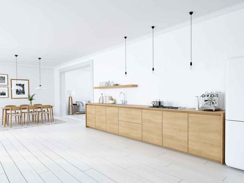 cucina in legno minimal con lampadine sospese, pareti di colore bianco, frigorifero bianco.