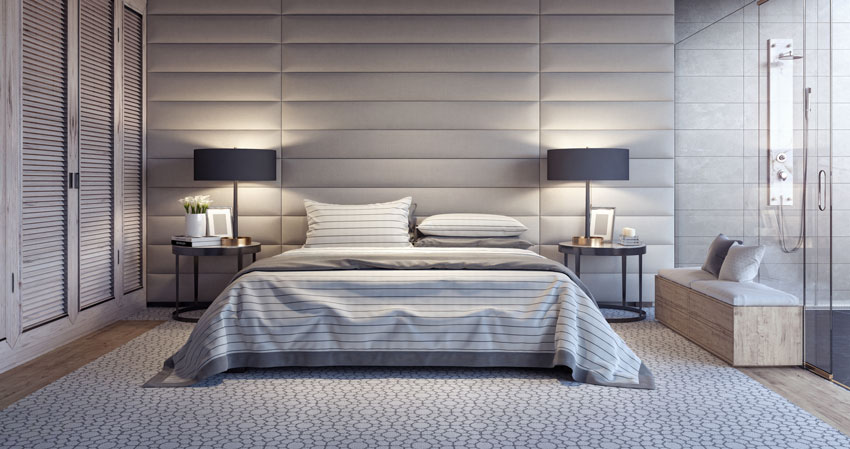 camera da letto elegante con intera parete imbottita in pelle beige, lampade da comodino nere.
