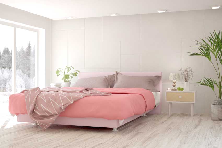 Camera da letto moderna bianca e rosa con piante verde.