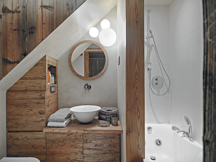 Un piccolo bagno in muratura stile rustico con rivestimento in legno e vasca doccia.