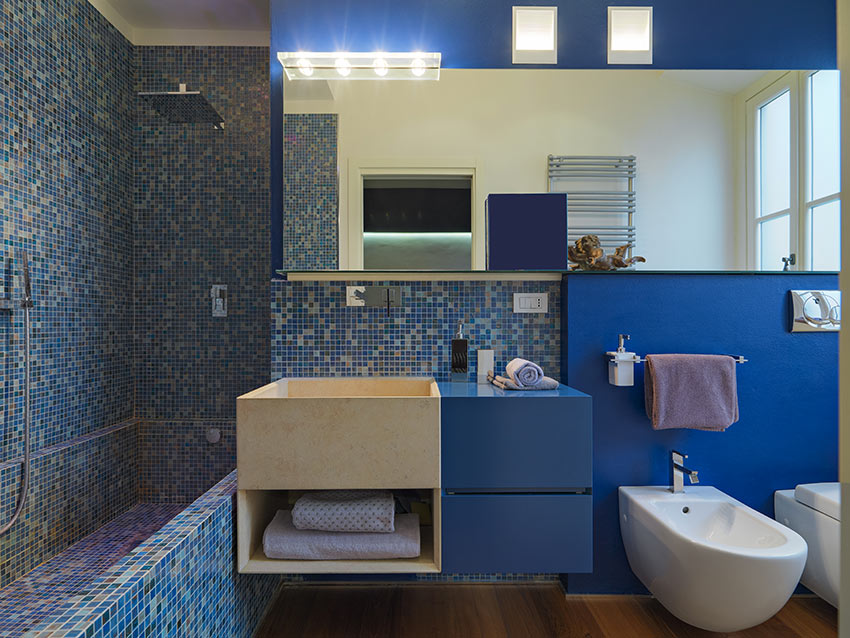 Bagno moderno con rivestimento in piastrelle blu effetto mosaico.