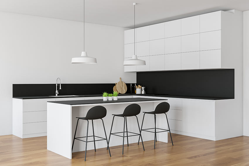 Cucina moderna di design bianca e nera ad angolo con isola centrale.