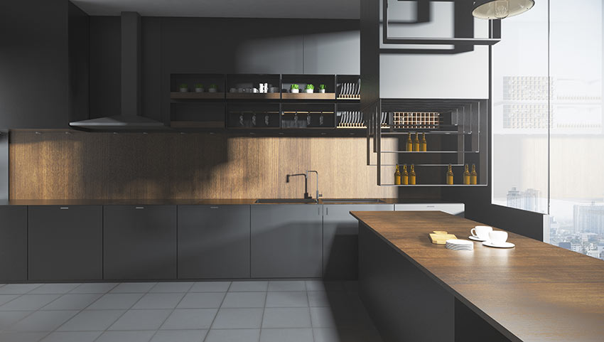 Grande cucina nera lineare con rivestimenti in legno e grande penisola con top in legno.