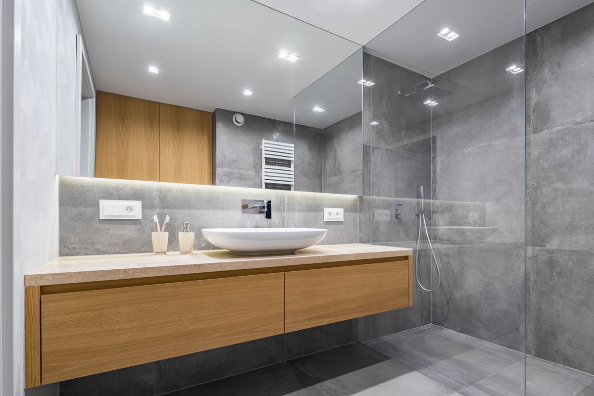 Bagno elegante grigio con mobile lavabo in legno.