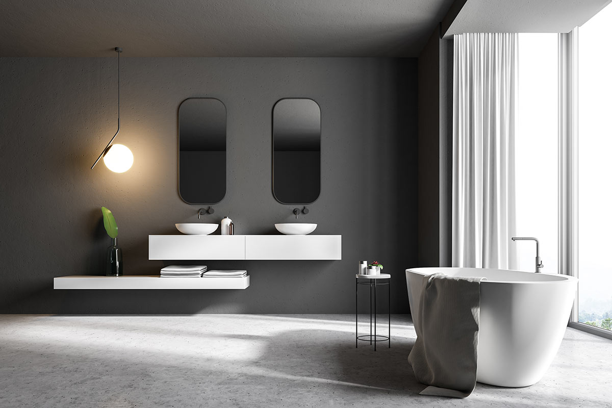 Bagno contemporaneo con mobili e vasca nera e parete scura.