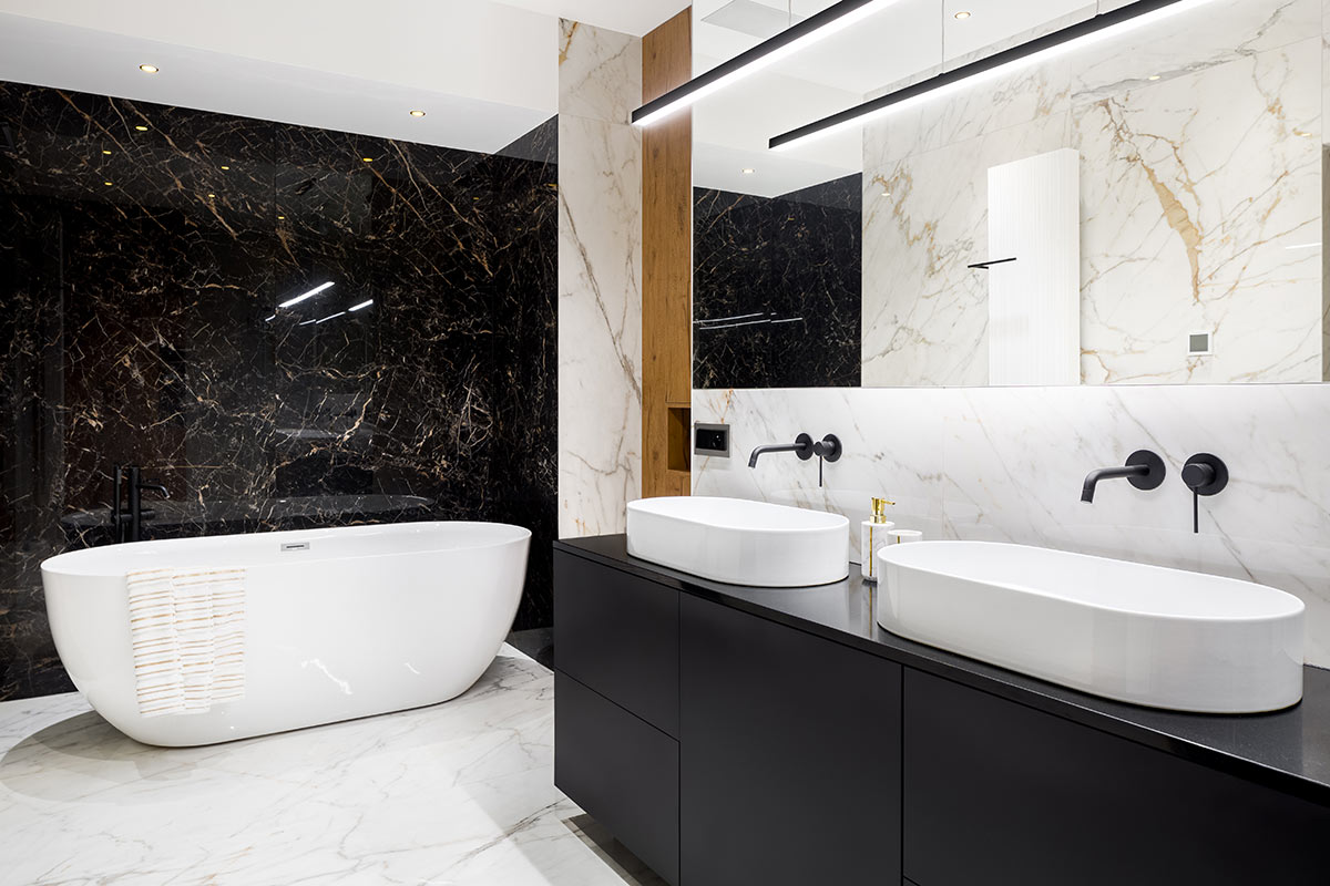 Bagno moderno bianco e nero con parete rivestite di marmo.