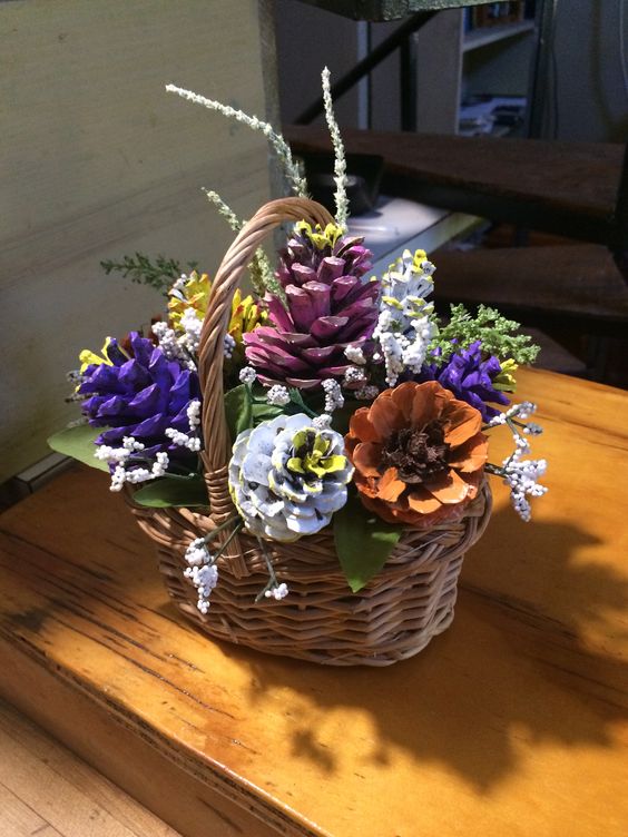 Bellissimo vaso in vimini con pigne colorate che sembrano fiori.