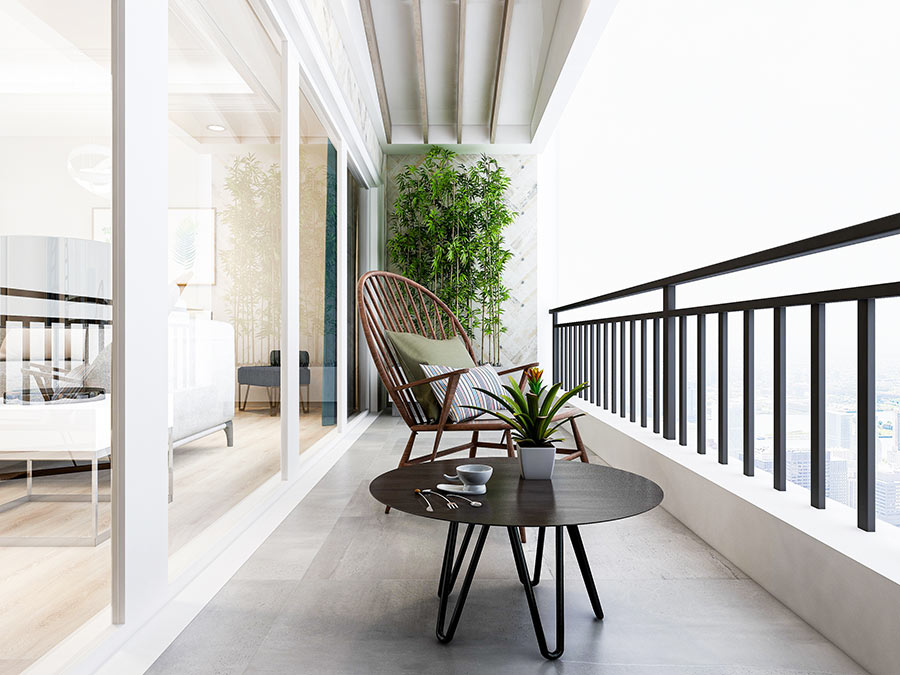 Bellissimo balcone lungo arredato con tavolino nero tondo e canne di bambou.