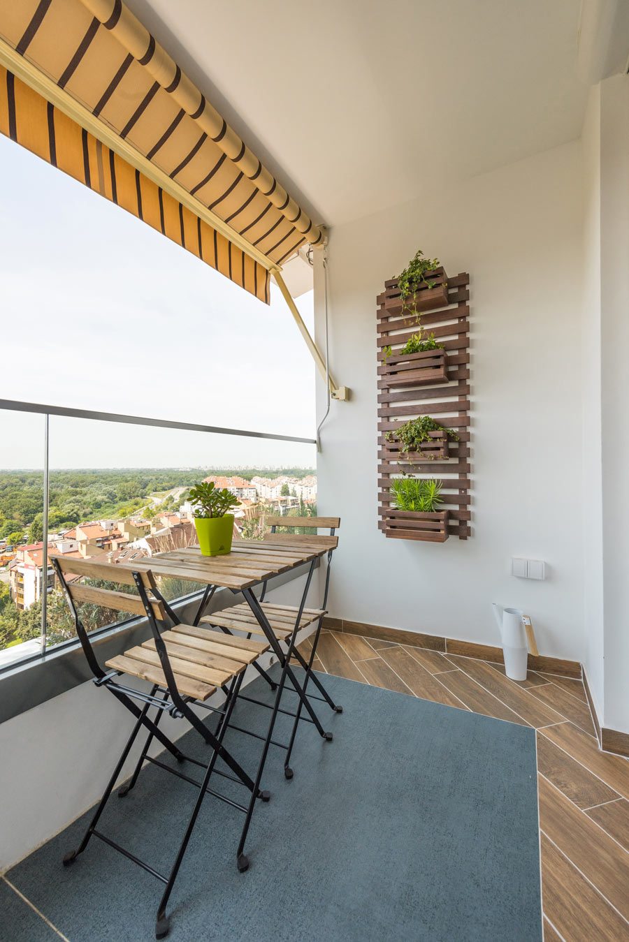 Balcone con fioriera fai da te in pallet e tavolino con 2 sedie.