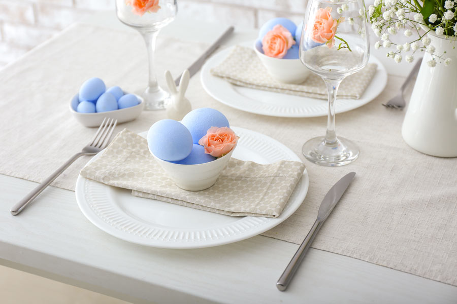 Tavola di Pasqua Shabby con ciotole bianche e ovetti blu pastello.