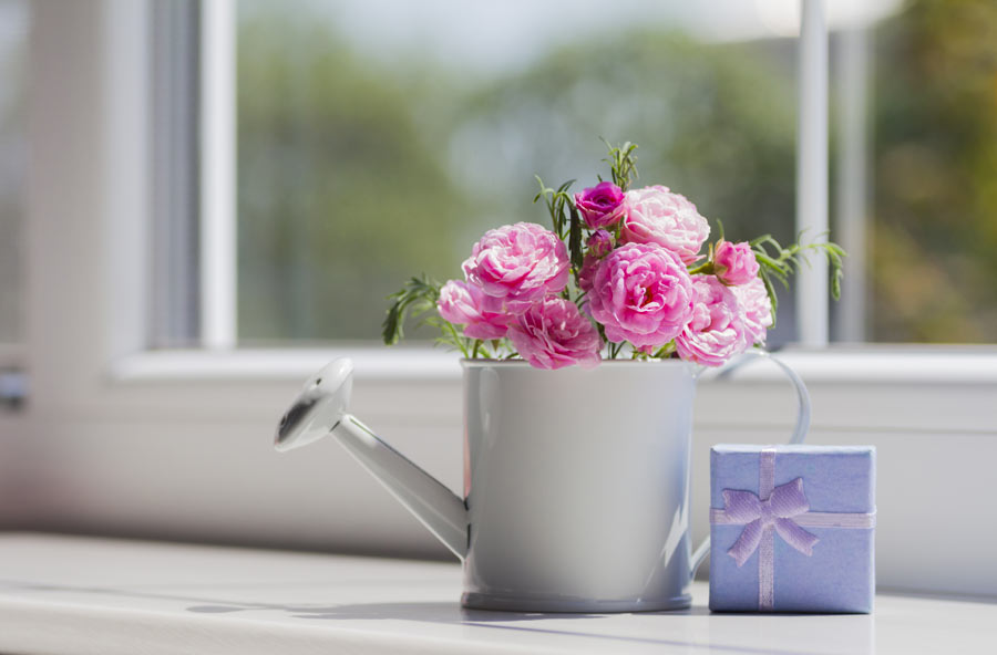 Innaffiatoio bianco decorato con delle rose.