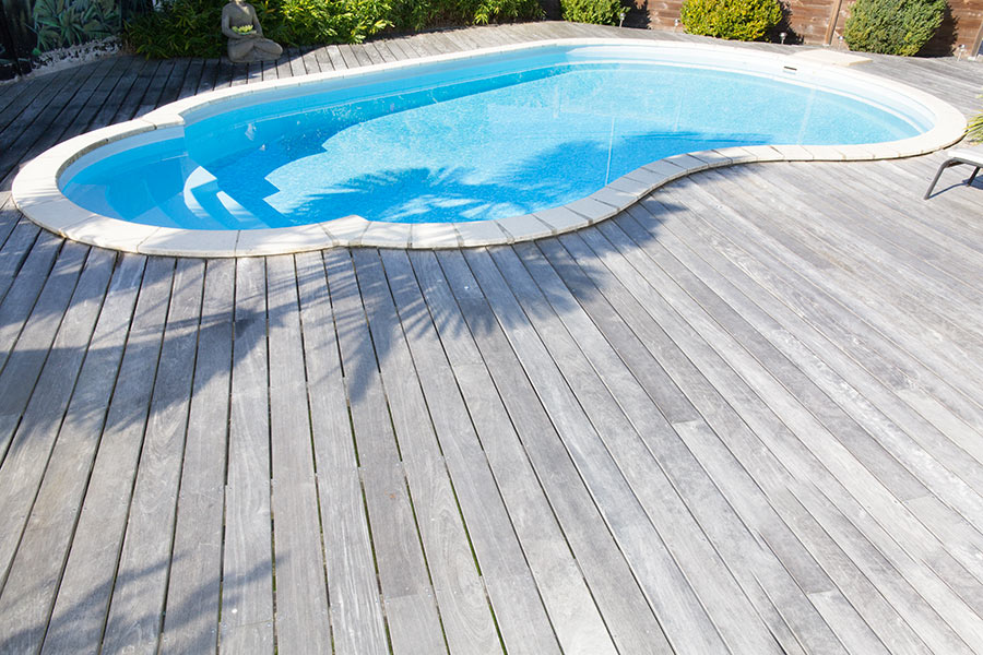 Pavimento in legno attorno piscina a forma libera.