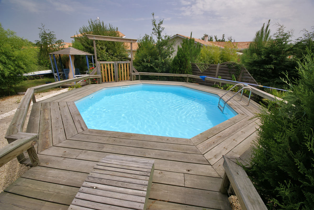 Piscina esagonale fuori terra con soppalco in legno.