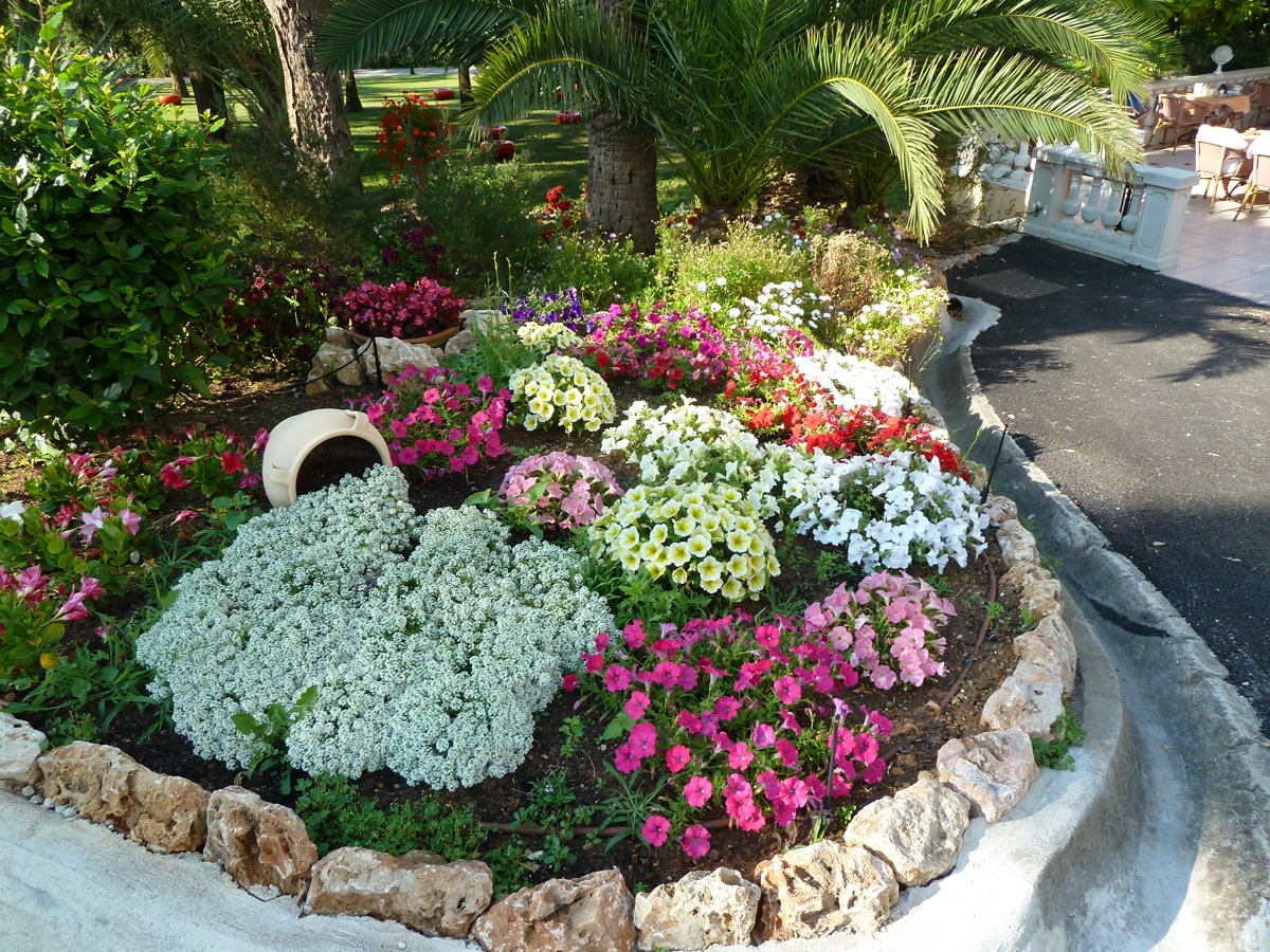 Splendida idea di aiuola con bordi in pietra naturale, fiori colorati.