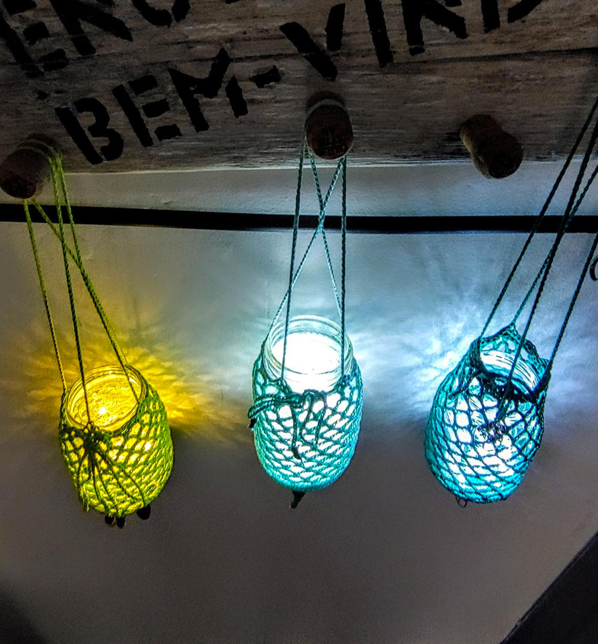 Lanterne sospese con barattoli di vetro rivestite con corda colorata.