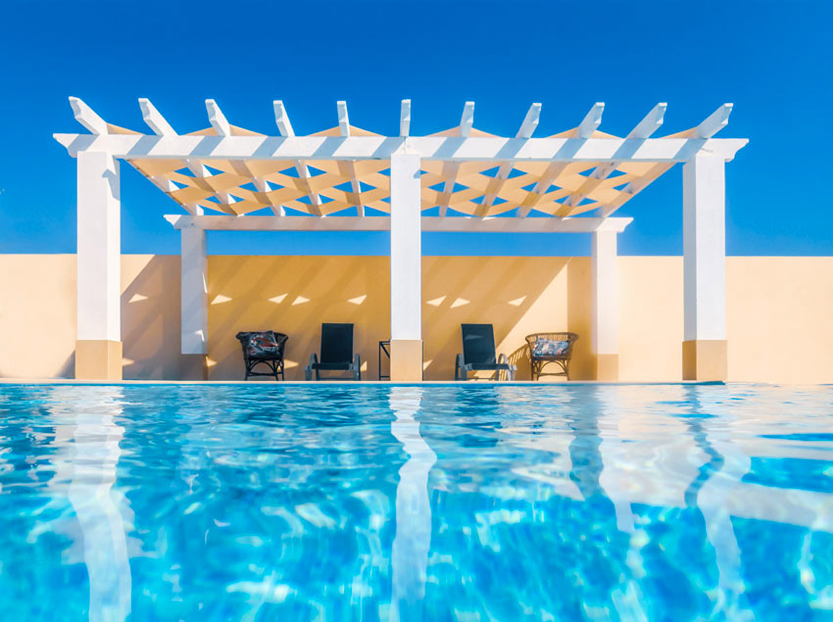 Piscina con pergola bianca in giardino