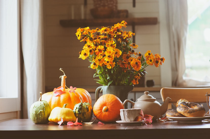 Fiori, zucche e tutti gli ortaggi di stagione sulla tavola in cucina