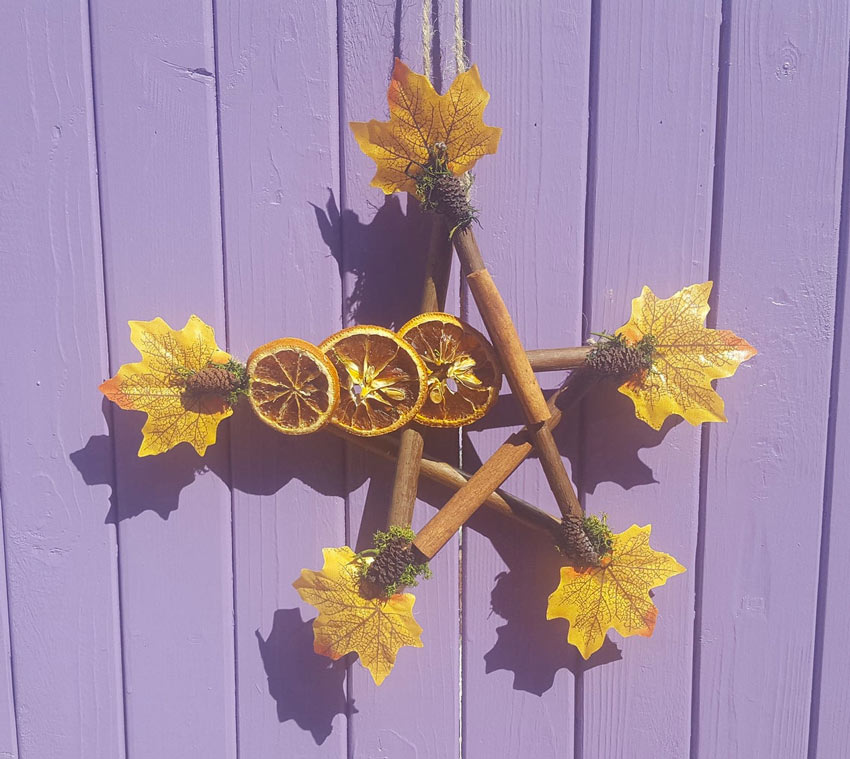 Decorazione autunnale realizzata con legnetti e frutta secca.