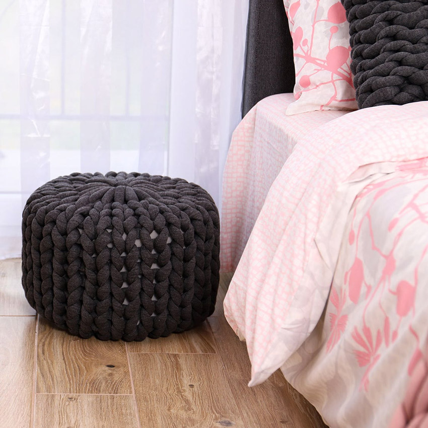 Bel pouf decorativo nero in camera da letto.