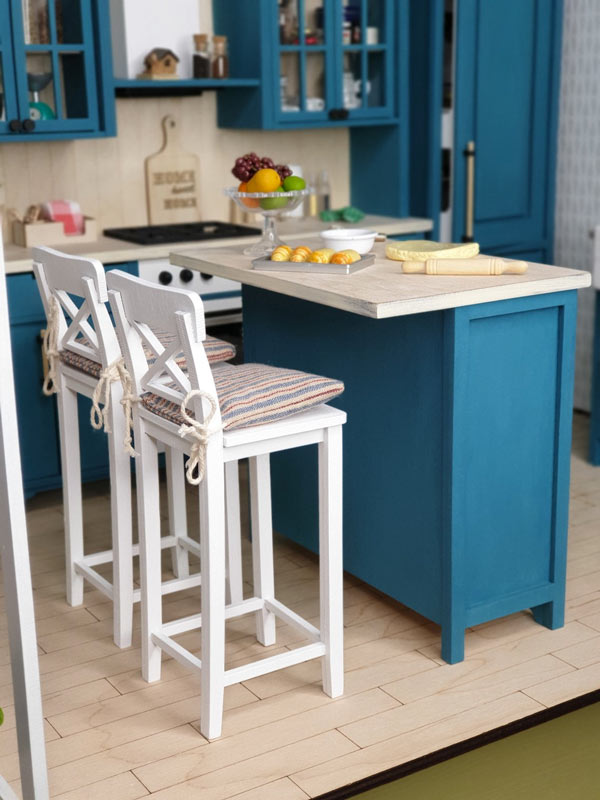 Piccola isola cucina con sgabelli alti bianchi stile country.