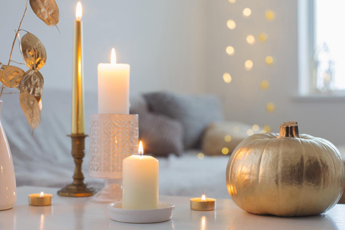 Bellissima composizione di candele con zucca dorata.