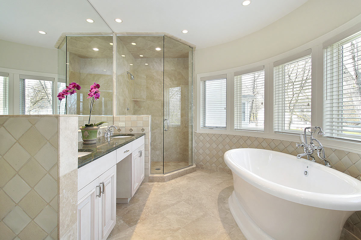 Bagno moderno color tortora rifatto in muratura con grande doccia ad angolo e vasca da bagno.
