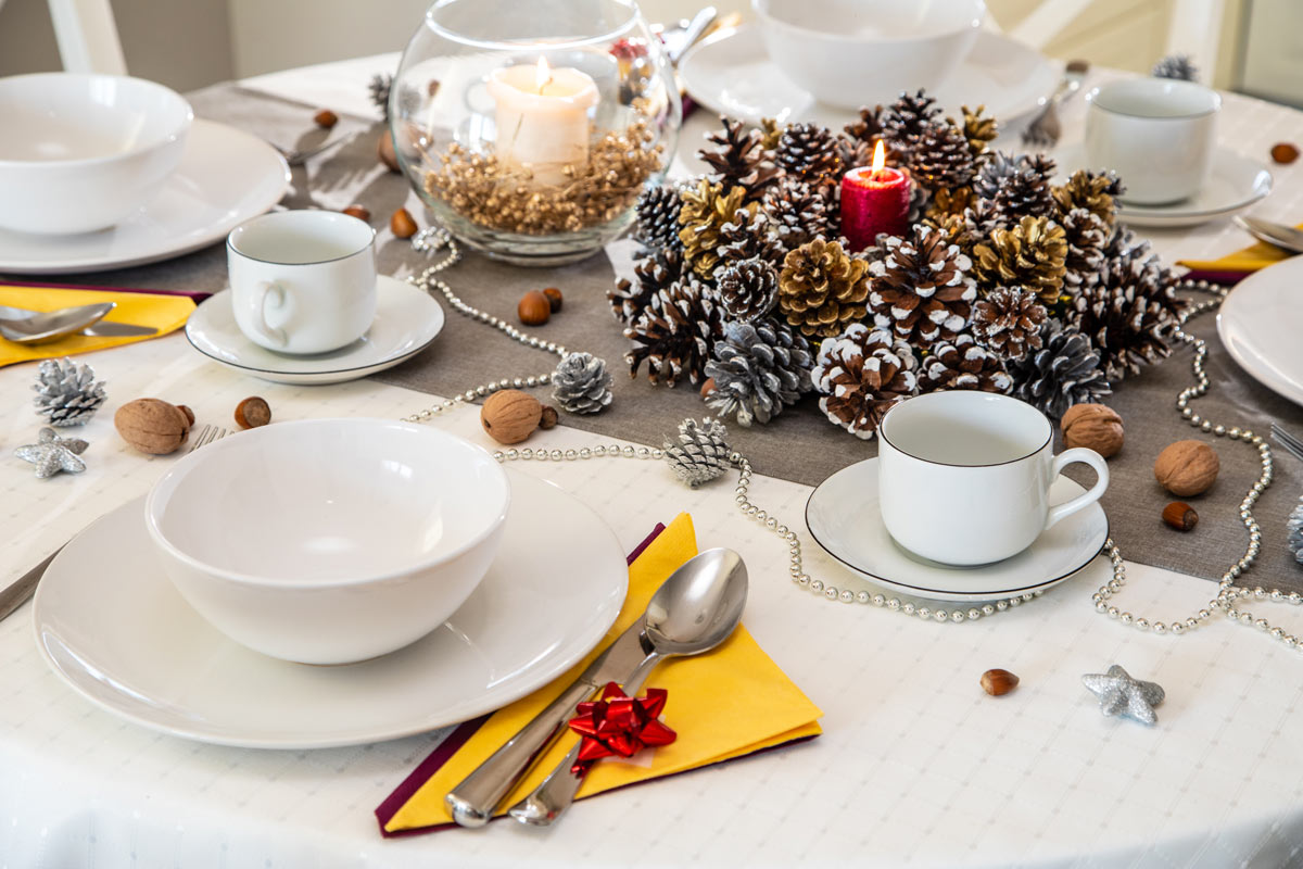 Decorare la tavola di Natale con le pigne.