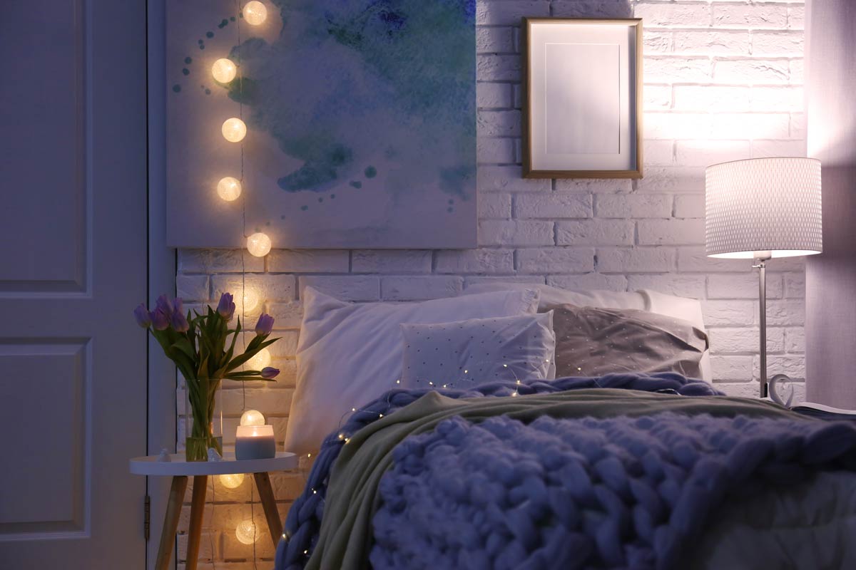 Camera da letto con parete a mattoni a vista bianchi.