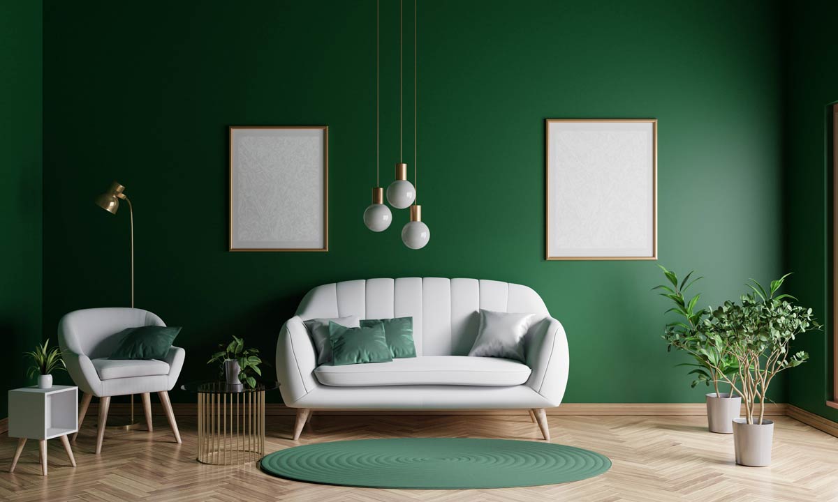 Parete verde con divanetto grigio chiaro in salotto.