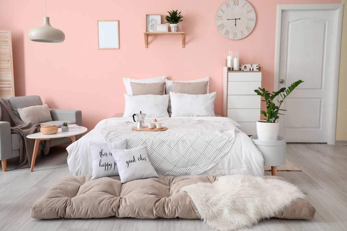 Bella camera da letto con parete rosa cipria.