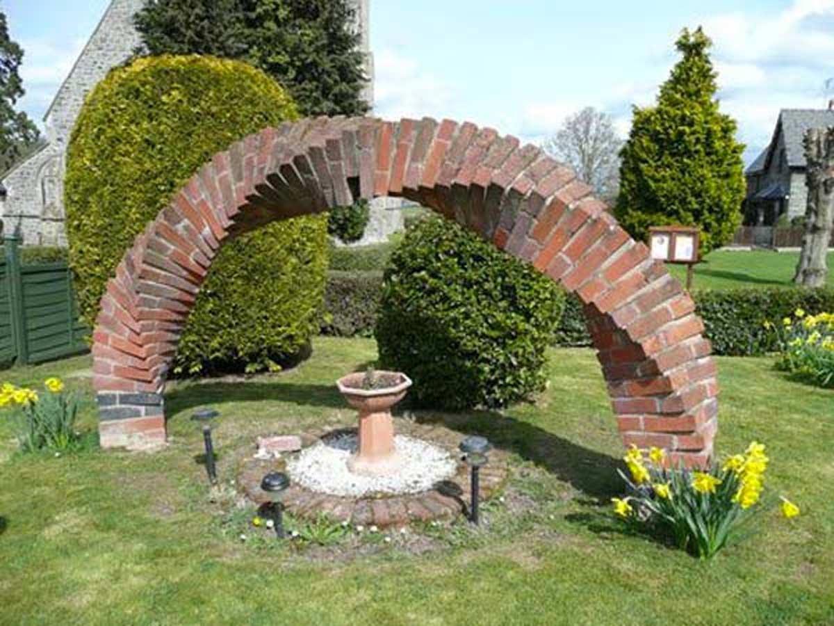 Arco realizzato con dei mattoni rossi in questo giardino.