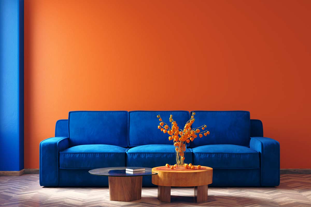 soggiorno con parete arancione e divano blu