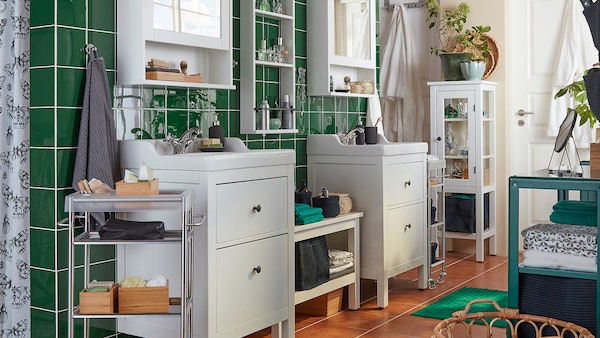 Un bagno con piastrelle verdi, due mobili per lavabo e a specchio bianchi HEMNES, asciugamani e accessori a vista - IKEA