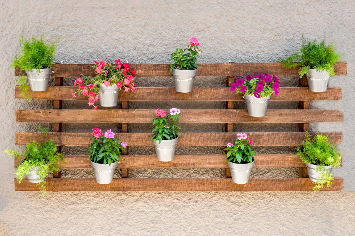 fioriere da parete fai da te in pallet con vasetti di fiori