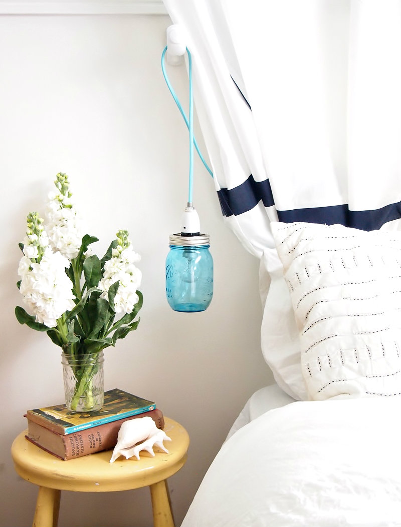 A DIY mason jar pendant light is a soothing reading light or nightlight for a bedroom in a tiny apartment.
