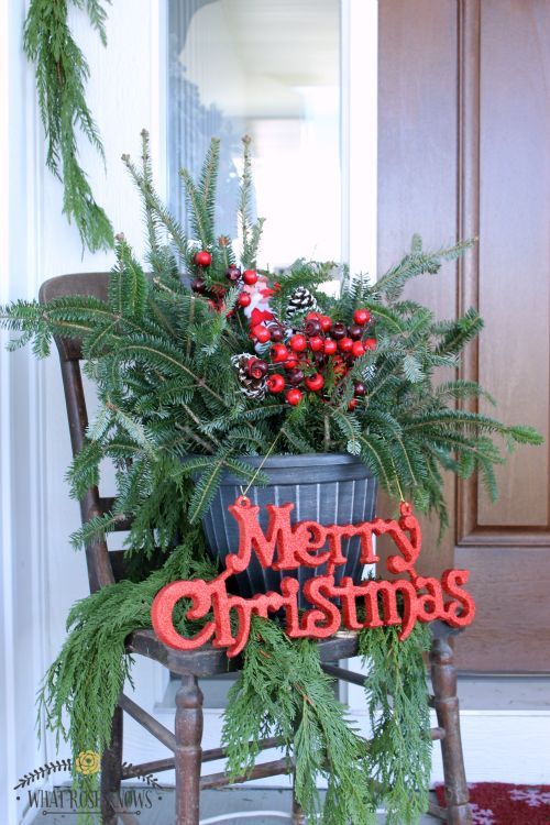 Vecchia sedia in legno decorata per Natale con un vaso di pino e scritta rossa "Merry Christmas".