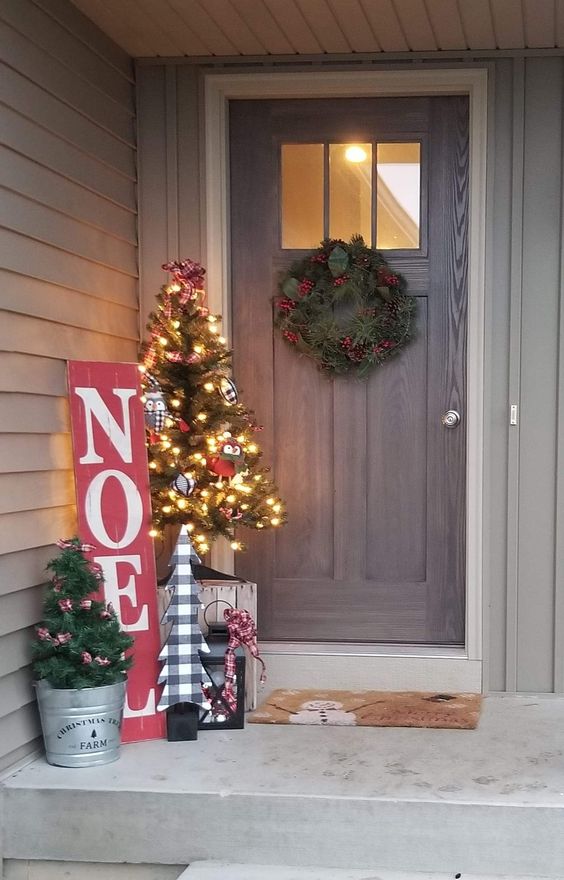 Alberelli, ghirlanda natalizia e insegna con pallet rossa con scritta "natale" in bianco.