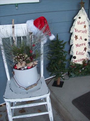 Sedia bianca con cappello babbo natale e vaso decorato.