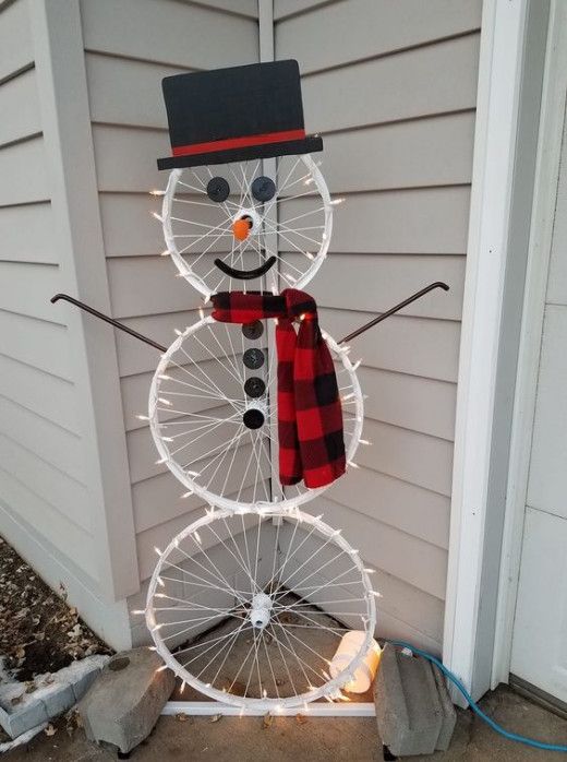 Pupazzo di neve con vecchie ruote bicicletta.