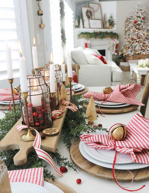 Centrotavola natalizio con tagliere in legno e graziose lanterne rustiche