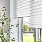 Tenda plissettata IKEA SCHOTTIS bianca su finestra con luce naturale e piante