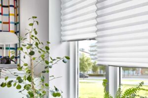 Tenda plissettata IKEA SCHOTTIS bianca su finestra con luce naturale e piante
