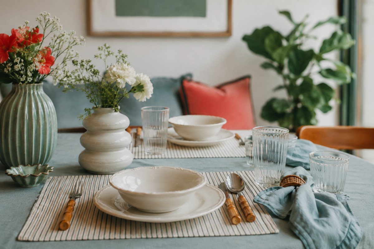 Tavola estiva con tovagliette a righe e ceramiche chiare