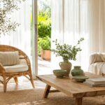 Soggiorno estivo luminoso con lino rattan legno chiaro e ceramica opaca