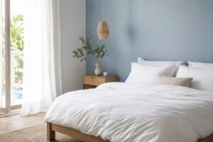 Camera da letto luminosa con parete azzurro polvere e legno chiaro