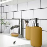 Dispenser IKEA EKOLN giallo scuro su lavabo bianco con rubinetto cromato