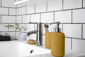 Dispenser IKEA EKOLN giallo scuro su lavabo bianco con rubinetto cromato